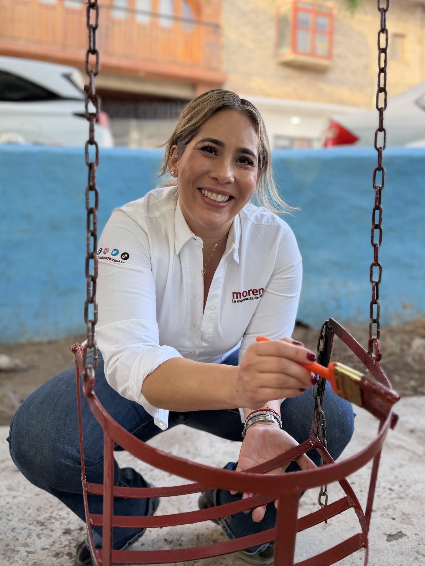 Andrea Tovar pintando una estructura metálica en un espacio público